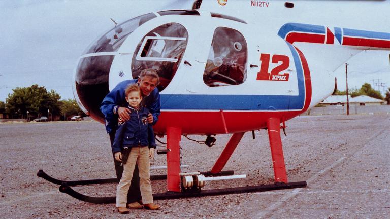 Chris standing in front of a news helicopter
