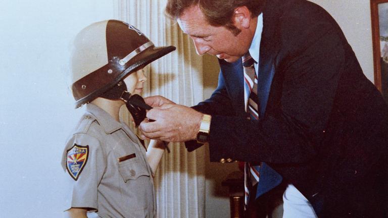 Make-A-Wish founder Allan Schmidt fastens a DPS helmet on Chris